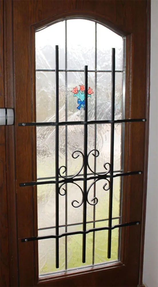 Haustür mit verziertem schwarzem Gitter vor dem Glasfeld