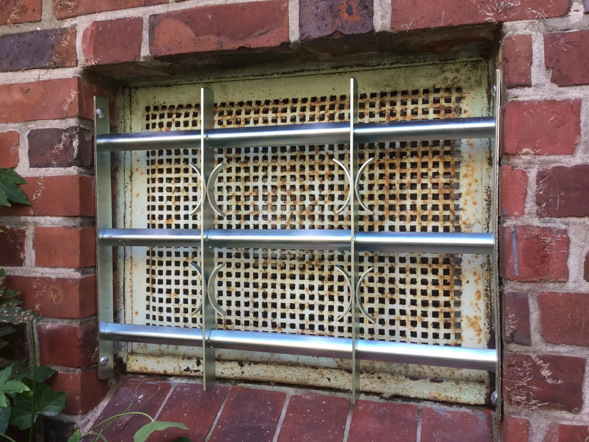 Kellerfenster in Backsteinwand mit verzinktem Stahlgitter