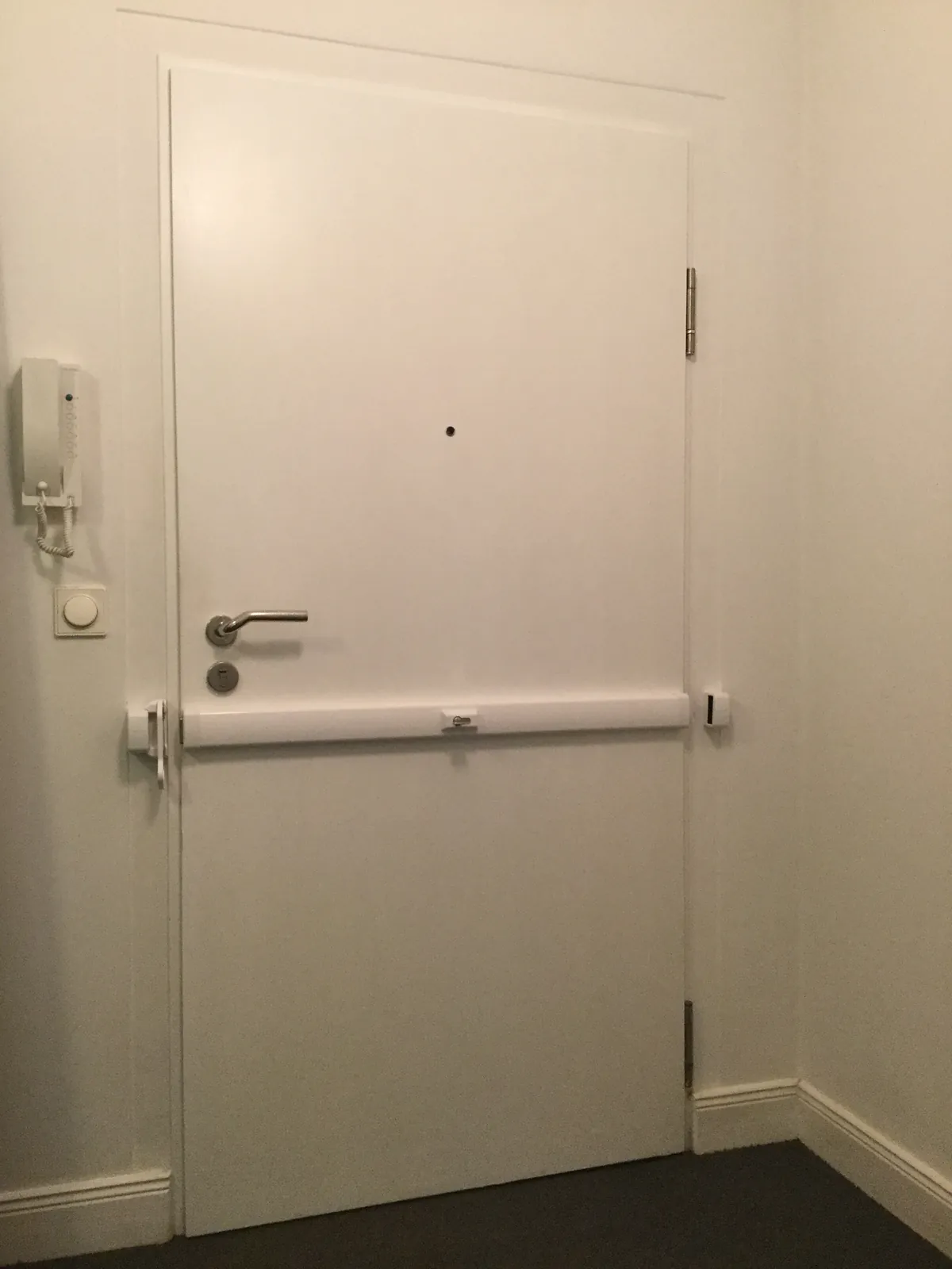 Weiße Wohnungstür mit Panzerriegel und Gegensprechanlage