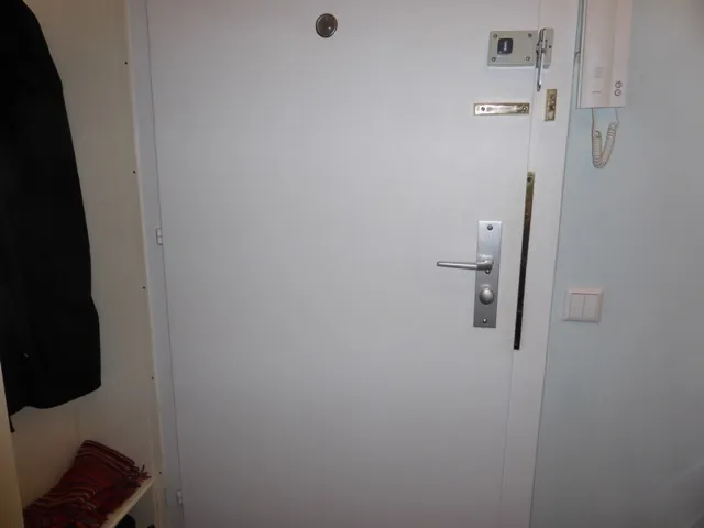 Weiße Wohnungstür mit Drücker und Türschild